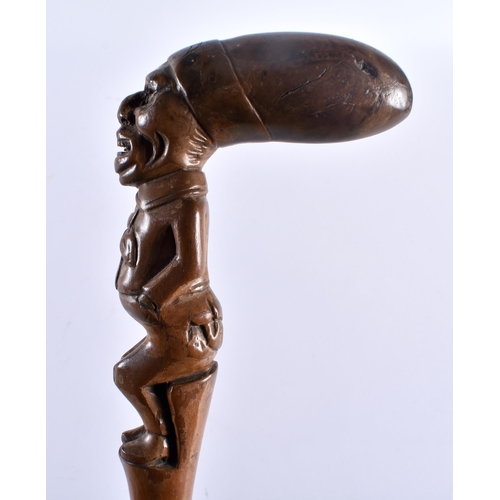 712 - AN ANTIQUE CONTINENTAL CARVED ELONGATED HEAD WOOD WALKING CANE. 88 cm long.