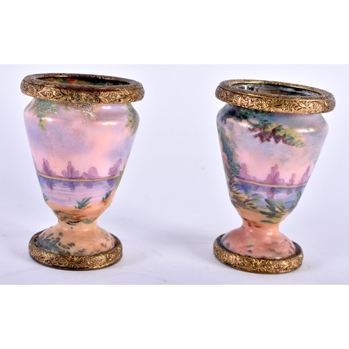 768 - A PAIR OF EARLY 20TH CENTURY FRENCH ENAMELLED VASES painted with landscapes. 6 cm x 4 cm.