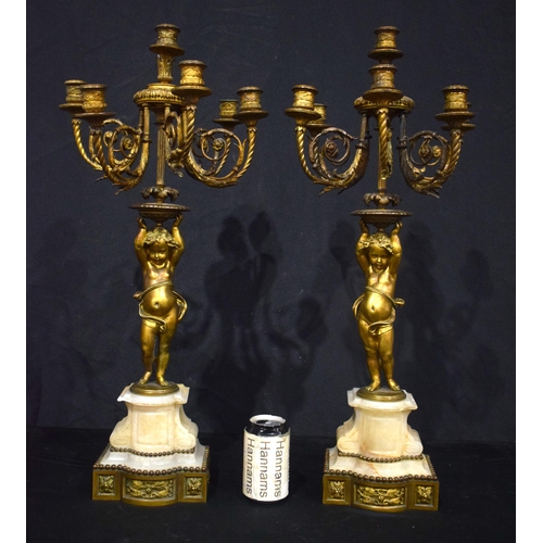 3993 - A pair of Putti bronze candelabras set on a marble base  68 cm (2)