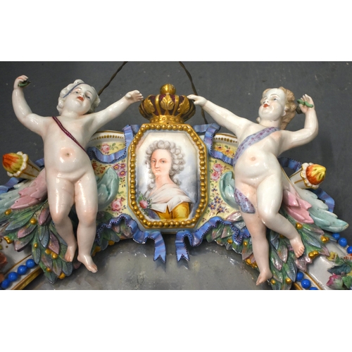 115E - A VERY LARGE 19TH CENTURY GERMAN MEISSEN PORCELAIN MIRROR set with two putti encasing a portrait of ... 