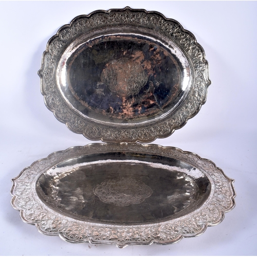 75C - A LARGE PAIR OF 19TH CENTURY INDIAN SILVER REPOUSSE SERVING TRAYS decorated with foliage and vines. ... 