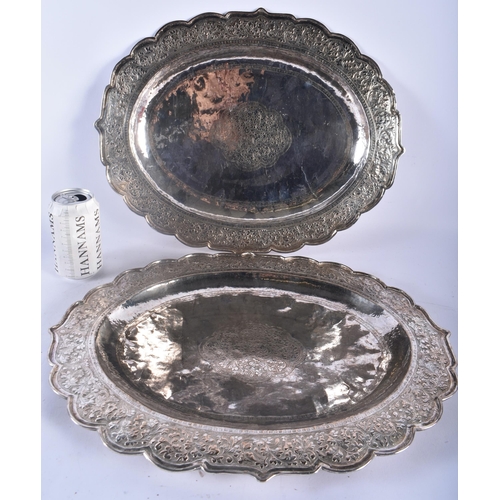 75C - A LARGE PAIR OF 19TH CENTURY INDIAN SILVER REPOUSSE SERVING TRAYS decorated with foliage and vines. ... 