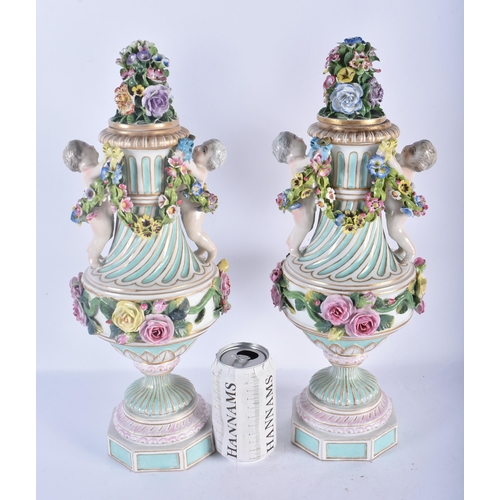 138 - A LARGE PAIR OF 19TH CENTURY GERMAN PORCELAIN TWIN HANDLED VASES AND COVERS modelled as putti holdin... 