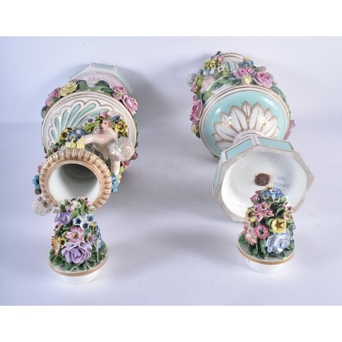 138 - A LARGE PAIR OF 19TH CENTURY GERMAN PORCELAIN TWIN HANDLED VASES AND COVERS modelled as putti holdin... 