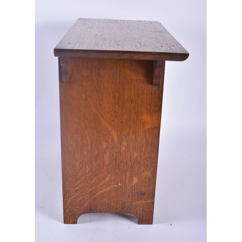 325 - AN ART NOUVEAU OAK SMOKERS CABINET with stylised brass strapwork. 30cm x 28 cm.