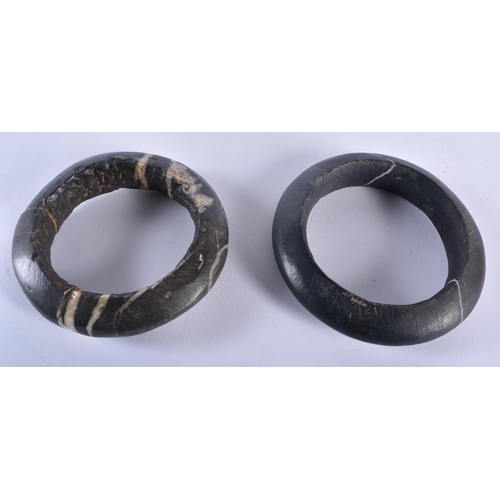 331 - A PAIR OF EARLY NIGERIAN AFRICAN TRIBAL CARVED STONE BANGLES together with a conch shell box and cov... 