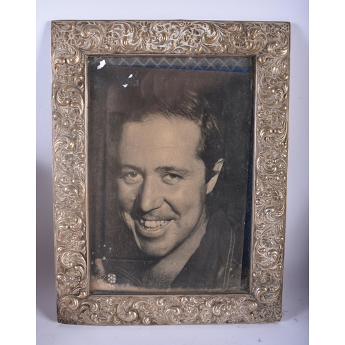 353 - AN ANTIQUE SILVER PHOTOGRAPH FRAME together with another repousse frame & a pair of Russian cup hold... 