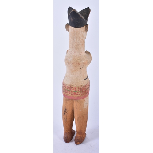 428 - AN UNUSUAL AFRICAN TRIBAL PAINTED WOOD FIGURE modelled with hands covering her breasts. 30cm high.