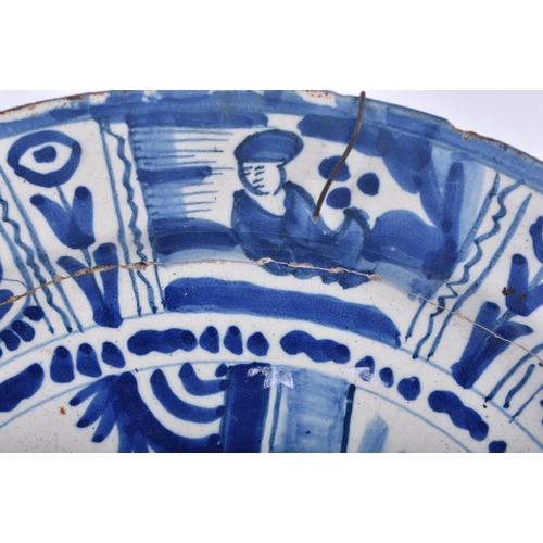 508 - AN EARLY DELFT TIN GLAZED POTTERY PLATE painted with a figure within a landscape. 32 cm diameter.