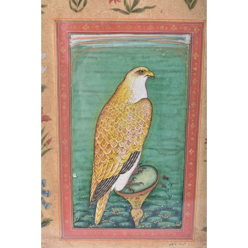 518 - A 19TH CENTURY PERSIAN ISLAMIC ILLUMINATED WATERCOLOUR painted with a hawk flanked by foliage. 38 cm... 