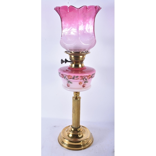 552 - A LARGE ANTIQUE BRASS AND PINK GLASS OIL LAMP. 60 cm high.