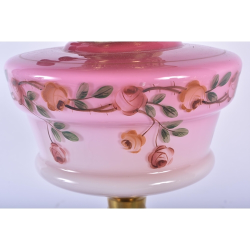 552 - A LARGE ANTIQUE BRASS AND PINK GLASS OIL LAMP. 60 cm high.