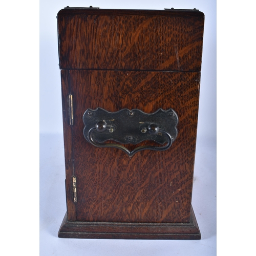 554 - A LARGE LATE VICTORIAN OAK CASED TANTALUS the top and front opening to reveal a fully fitted interio... 