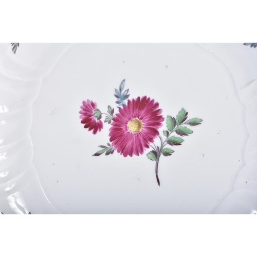 557 - AN 18TH/19TH CENTURY MEISSEN SCALLOPED PORCELAIN PLATE painted with flowers. 22 cm wide.