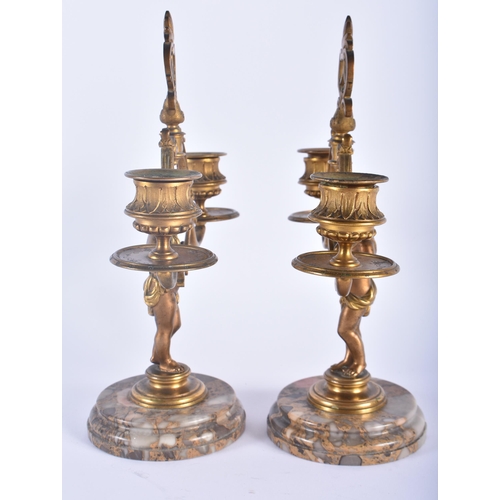 561 - A PAIR OF 19TH CENTURY FRENCH BRONZE FIGURAL CANDLESTICKS formed as nudes upon marble plinths. 23 cm... 