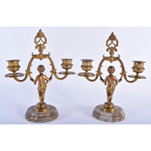 561 - A PAIR OF 19TH CENTURY FRENCH BRONZE FIGURAL CANDLESTICKS formed as nudes upon marble plinths. 23 cm... 