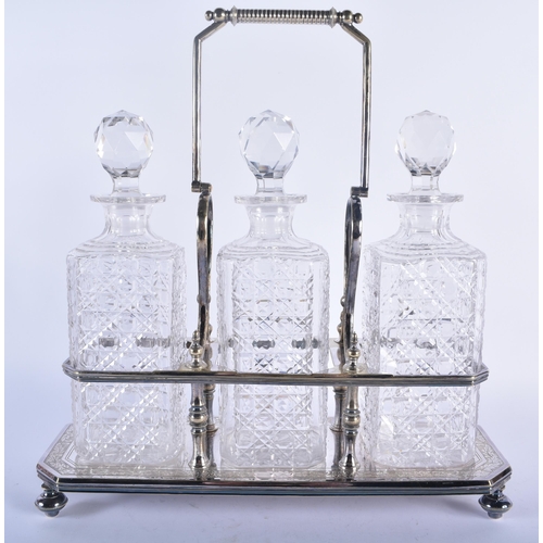 600 - AN ANTIQUE SILVER PLATED CUT GLASS TANTALUS. 38 cm x 32 cm.