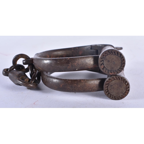 702 - A PAIR OF ANTIQUE HANDCUFFS together with a similar padlock. Largest 24 cm long. (3)