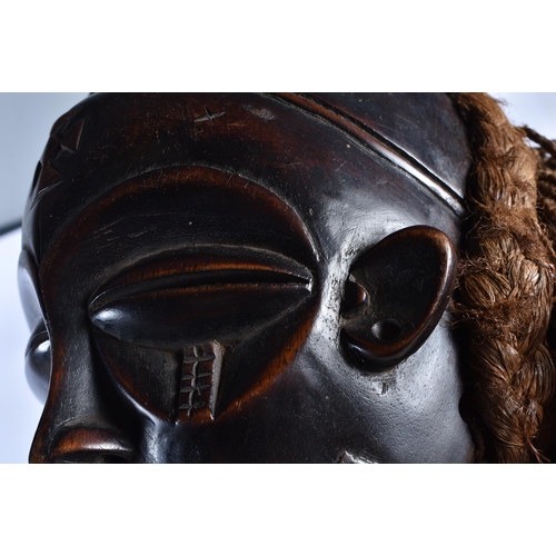 74 - A LARGE EARLY 20TH CENTURY AFRICAN TRIBAL WOOD MASK with later stand. 58 cm x 14 cm.