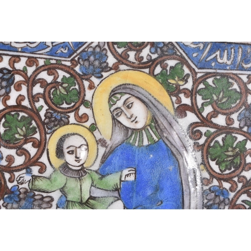 803 - A 19TH CENTURY PERSIAN QAJAR POTTERY TILE painted with a female and child amongst calligraphy. 20 cm... 