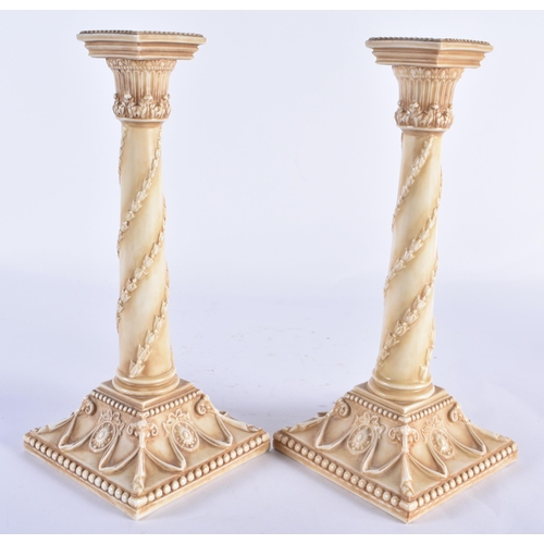 853 - A PAIR OF ROYAL WORCESTER BLUSH IVORY CANDLESTICKS. 27 cm high.