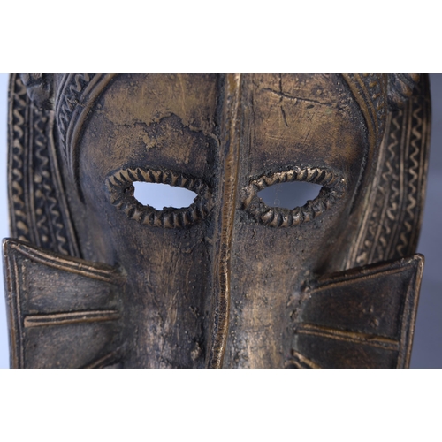 866 - A PAIR OF AFRICAN BRONZE TRIBAL MASKS. 35 cm x 10 cm.