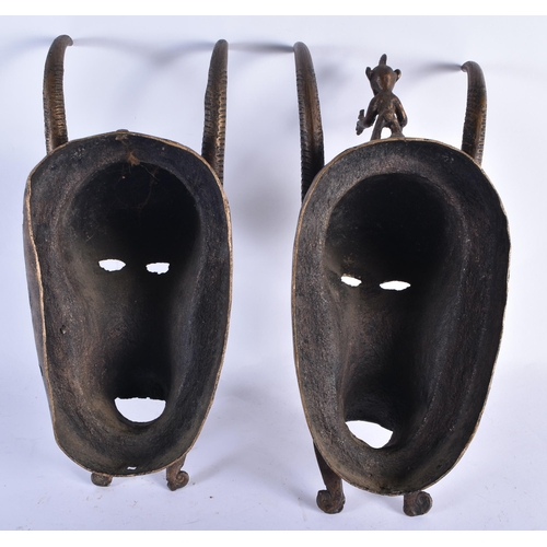 866 - A PAIR OF AFRICAN BRONZE TRIBAL MASKS. 35 cm x 10 cm.