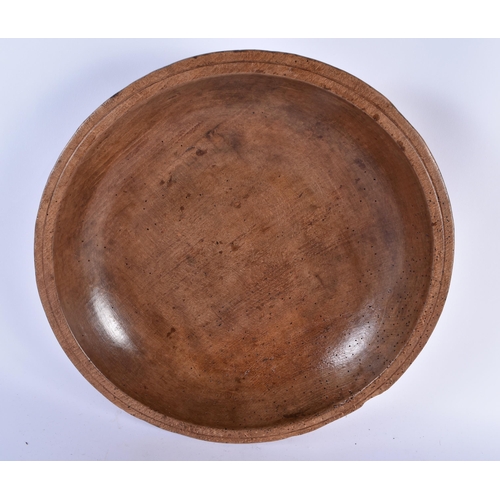 875 - A CARVED DAIRY WOOD TREEN BUTTER BOWL AND SPOON. Bowl 40 cm diameter. (2)