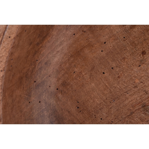 875 - A CARVED DAIRY WOOD TREEN BUTTER BOWL AND SPOON. Bowl 40 cm diameter. (2)