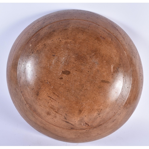 875 - A CARVED DAIRY WOOD TREEN BUTTER BOWL AND SPOON. Bowl 40 cm diameter. (2)