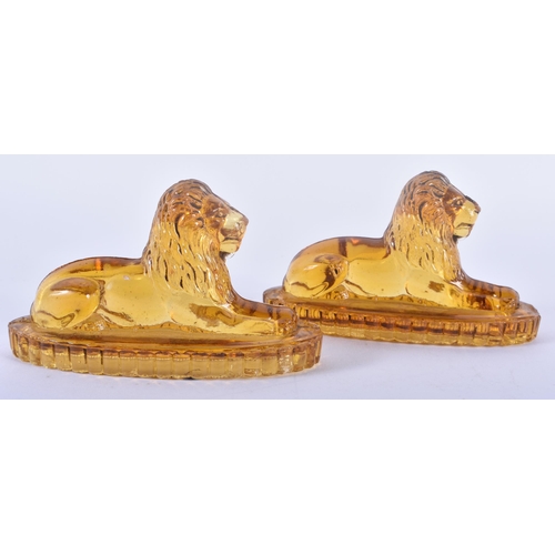 91 - A PAIR OF ANTIQUE MUSTARD YELLOW PRESSED GLASS LIONS. 12 cm x 8 cm.