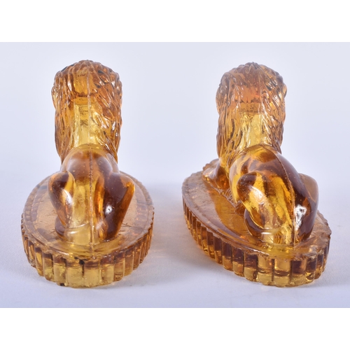 91 - A PAIR OF ANTIQUE MUSTARD YELLOW PRESSED GLASS LIONS. 12 cm x 8 cm.