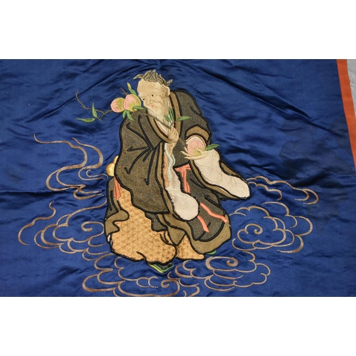 965 - A Chinese Silk Panel of a Sage Holding a Peach Blossom. 68cm x 71cm