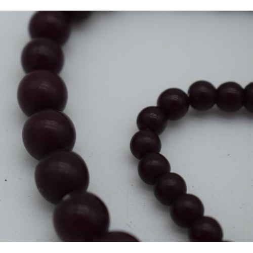 1015 - A DEEP RED CHERRY AMBER TYPE NECKLACE. 37 grams. 76 cm long, largest bead 1 cm diameter.