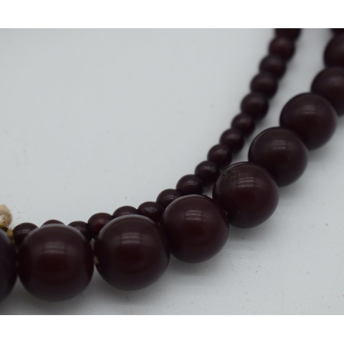 1015 - A DEEP RED CHERRY AMBER TYPE NECKLACE. 37 grams. 76 cm long, largest bead 1 cm diameter.