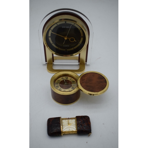 1050 - A TRAVELLING MOVADO LEATHER CASED WATCH together with two clocks. Largest 15cm x 10cm. (3)