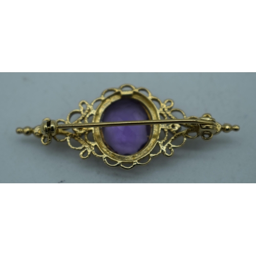 1094 - A YELLOW METAL AMETHYST BROOCH. 4.25 grams. 4.25cm x 1.75 cm.