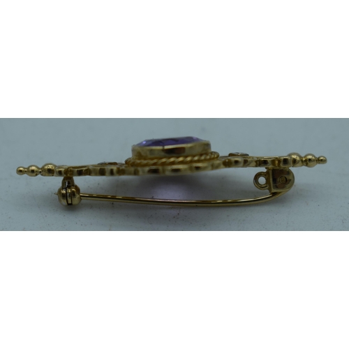 1094 - A YELLOW METAL AMETHYST BROOCH. 4.25 grams. 4.25cm x 1.75 cm.