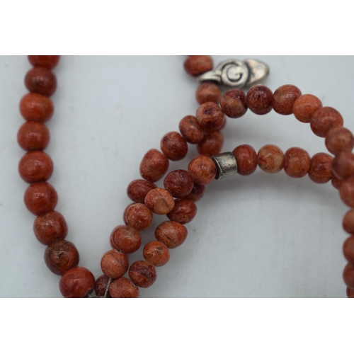 1111 - AN IMITATION CORAL WOOD NECKLACE. 35 grams. 22 cm long.