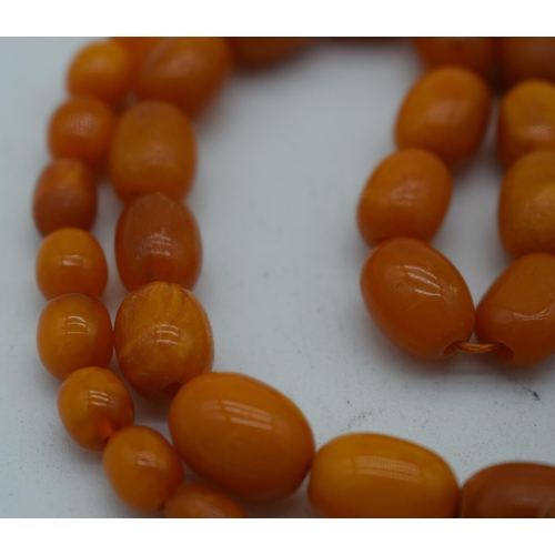 1118 - AN AMBER AND AGATE NECKLACE. 41 grams. 82 cm long. Largest amber bead 1.75 cm x 0.75 cm.