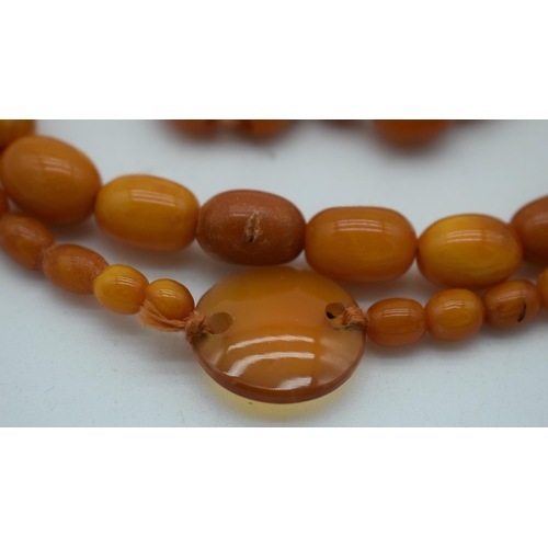 1118 - AN AMBER AND AGATE NECKLACE. 41 grams. 82 cm long. Largest amber bead 1.75 cm x 0.75 cm.