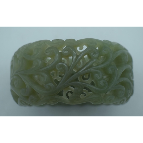 1131 - A CHINESE CARVED JADE RETICULATED BANGLE. 95 grams. 5.75 cm wide internally.