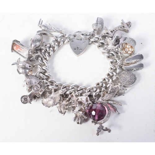 1371 - A Vintage Silver Charm Bracelet with 23 Charms.  Bracelet Hallmarked Birmingham 1966.  4.2 cm intern... 