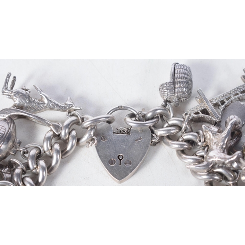 1371 - A Vintage Silver Charm Bracelet with 23 Charms.  Bracelet Hallmarked Birmingham 1966.  4.2 cm intern... 