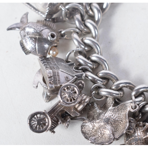 1371 - A Vintage Silver Charm Bracelet with 23 Charms.  Bracelet Hallmarked Birmingham 1966.  4.2 cm intern... 