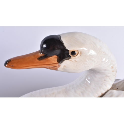 126 - A LARGE PAIR OF 19TH CENTURY CONTINENTAL COUNTRY HOUSE CERAMIC FIGURES OF SWANS modelled with natura... 