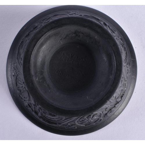 128 - A WEDGWOOD BLACK BASALT FLARED BOWL decorated with floral sprays. 8 cm diameter.