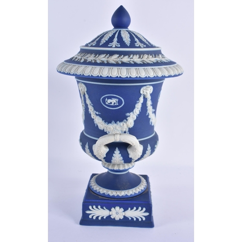 132 - A WEDGWOOD BLUE BASALT TWIN HANDLED VASE AND COVER decorated with swags and trailing floral wreaths.... 