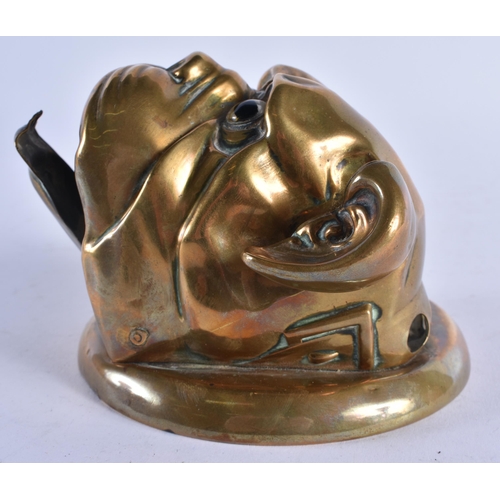 397 - AN ANTIQUE ARTICULATED BRASS GLASS EYED BULLDOG WALL MOUNT possibly formerly a bell. 12 cm wide.