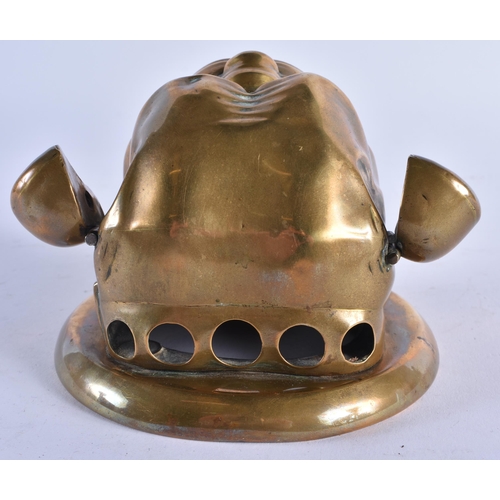 397 - AN ANTIQUE ARTICULATED BRASS GLASS EYED BULLDOG WALL MOUNT possibly formerly a bell. 12 cm wide.